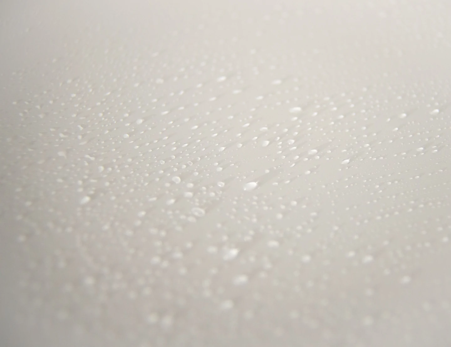 Pequenas gotas transparentes sobre superfície branca